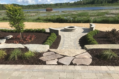 Photo of a mid-sized contemporary backyard brick landscaping in Detroit.