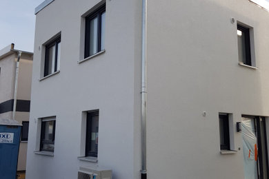 Mittelgroßes, Zweistöckiges Modernes Einfamilienhaus mit Putzfassade, weißer Fassadenfarbe und Flachdach in Stuttgart