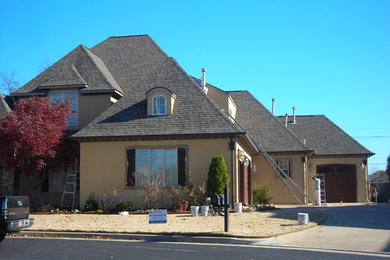 Example of a large classic brown two-story stucco exterior home design in Other
