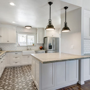 Small farmhouse kitchen pantry appliance - Inspiration for a small country galley ceramic floor kitchen pantry remodel in San Diego with a farmhouse sink, shaker cabinets, white cabinets, granite countertops, white backsplash, porcelain backsplash, stainless steel appliances and a peninsula