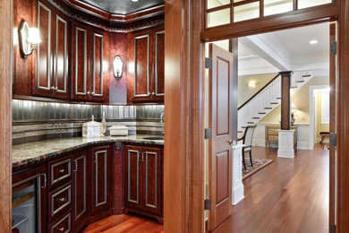 Wet bar - small traditional l-shaped medium tone wood floor wet bar idea in Minneapolis with an undermount sink, flat-panel cabinets, granite countertops, multicolored backsplash, mosaic tile backsplash and multicolored countertops