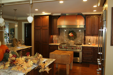 Enclosed kitchen - large traditional l-shaped enclosed kitchen idea in Columbus with raised-panel cabinets, dark wood cabinets, granite countertops, multicolored backsplash, matchstick tile backsplash, stainless steel appliances, an island and gray countertops