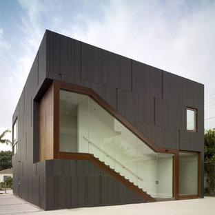 Exempel på ett mellanstort modernt svart hus, med allt i ett plan, metallfasad och platt tak