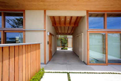 他の地域にあるモダンスタイルのおしゃれな玄関 (木目調のドア、グレーの床、板張り天井、板張り壁) の写真