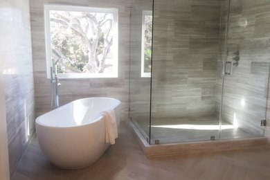 Design ideas for a mid-sized contemporary master bathroom in Other with flat-panel cabinets, dark wood cabinets, a freestanding tub, a double shower, beige walls, an undermount sink, beige floor and a hinged shower door.