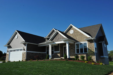 Example of a large arts and crafts brown one-story vinyl gable roof design in Chicago