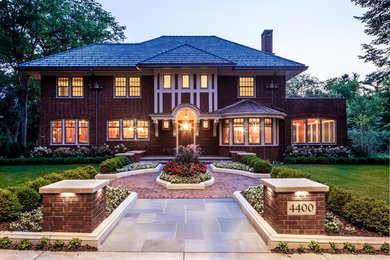 Arts and crafts red two-story brick house exterior photo in Minneapolis with a hip roof and a tile roof