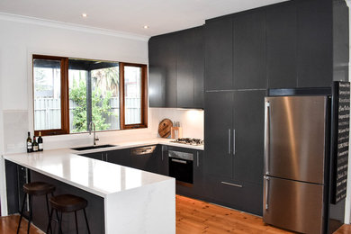 Inspiration for a mid-sized contemporary u-shaped open plan kitchen in Adelaide with a double-bowl sink, blue cabinets, white splashback, stone slab splashback, stainless steel appliances, flat-panel cabinets, marble benchtops, medium hardwood floors and a peninsula.