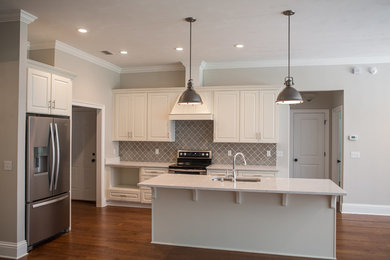 Open concept kitchen - large transitional l-shaped dark wood floor and brown floor open concept kitchen idea in Atlanta with an undermount sink, raised-panel cabinets, white cabinets, marble countertops, gray backsplash, ceramic backsplash, stainless steel appliances and an island