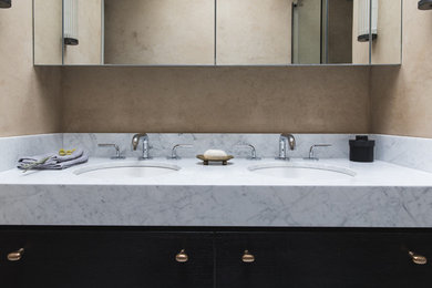 Exempel på ett mellanstort modernt badrum med dusch, med släta luckor, svarta skåp, en öppen dusch, en vägghängd toalettstol, beige väggar, marmorgolv, ett integrerad handfat, marmorbänkskiva, vitt golv och dusch med skjutdörr