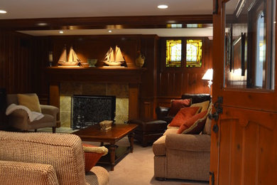 This is an example of a large traditional walk-out basement in Milwaukee with carpet, a standard fireplace, a tile fireplace surround, brown walls and beige floor.