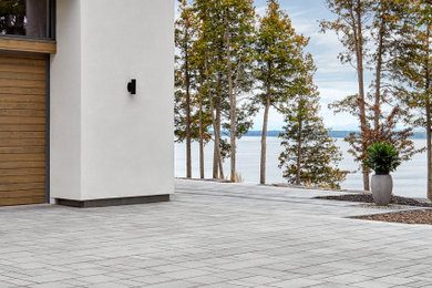 Inspiration for a modern front yard driveway in Montreal with concrete pavers.
