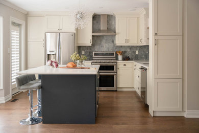 Example of a mid-sized transitional l-shaped dark wood floor and brown floor eat-in kitchen design in Toronto with an undermount sink, shaker cabinets, white cabinets, quartz countertops, gray backsplash, marble backsplash, stainless steel appliances, an island and multicolored countertops