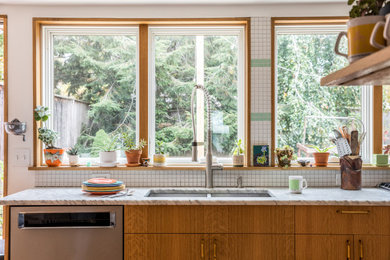 Mid-sized eclectic u-shaped eat-in kitchen in Portland Maine with an undermount sink, flat-panel cabinets, medium wood cabinets, marble benchtops, white splashback, ceramic splashback, stainless steel appliances, medium hardwood floors, no island, brown floor and grey benchtop.