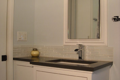Small trendy blue tile and glass tile porcelain tile bathroom photo in Portland with flat-panel cabinets, white cabinets, blue walls, an undermount sink, quartz countertops and a two-piece toilet