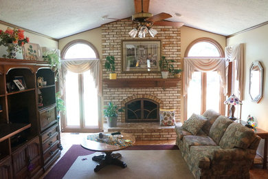 Inspiration for a timeless enclosed medium tone wood floor living room remodel in Detroit with beige walls, a standard fireplace, a brick fireplace and a media wall