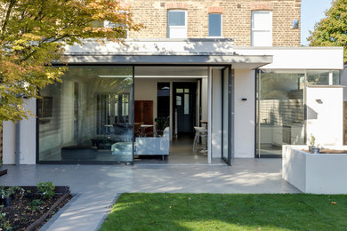 This is an example of a large contemporary three-storey stucco white house exterior in London with a flat roof and a metal roof.