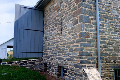 Mid-sized farmhouse two-story stone exterior home photo in DC Metro
