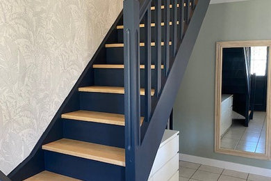 Idées déco pour un escalier peint courbe classique avec des marches en bois, un garde-corps en bois et du papier peint.