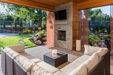 Example of a mid-sized transitional backyard decomposed granite patio design in Chicago with a fire pit and a roof extension