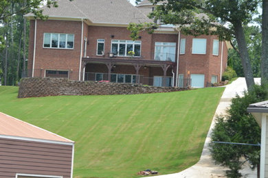 Large arts and crafts red two-story brick house exterior photo in Other with a shingle roof