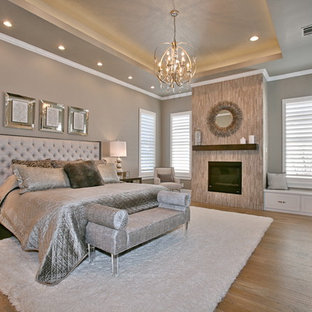 Foto på ett stort funkis huvudsovrum, med beige väggar, ljust trägolv, en standard öppen spis och en spiselkrans i trä