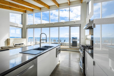Example of a mid-sized trendy single-wall light wood floor eat-in kitchen design in Vancouver with a drop-in sink, flat-panel cabinets, white cabinets, quartzite countertops, gray backsplash, porcelain backsplash, stainless steel appliances and an island