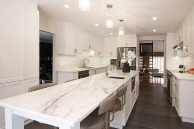 Inspiration for a contemporary u-shaped porcelain tile and gray floor kitchen remodel in Montreal with a single-bowl sink, recessed-panel cabinets, white cabinets, quartz countertops, white backsplash, porcelain backsplash, an island and white countertops