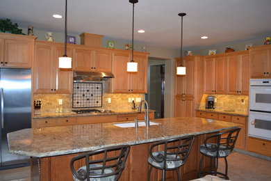 Inspiration for a mid-sized transitional l-shaped eat-in kitchen remodel in Sacramento with an undermount sink, raised-panel cabinets, medium tone wood cabinets, granite countertops, stainless steel appliances and an island