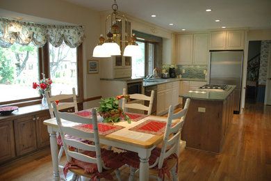 Eat-in kitchen - traditional l-shaped medium tone wood floor eat-in kitchen idea in Minneapolis with a double-bowl sink, raised-panel cabinets, beige cabinets, granite countertops, stainless steel appliances and an island