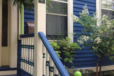 This is an example of a small victorian front porch design in New York with a roof extension.