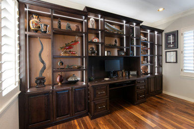 Aménagement d'un bureau classique de taille moyenne avec un mur gris, parquet clair, un bureau intégré et un sol marron.