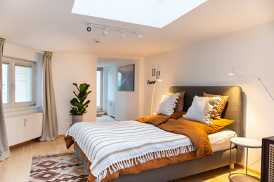 Modernes Schlafzimmer mit weißer Wandfarbe, hellem Holzboden und beigem Boden in Berlin