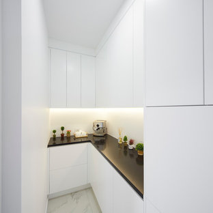 Modern kitchen pantry remodeling - Inspiration for a modern ceramic floor kitchen pantry remodel in Christchurch with white cabinets, gray backsplash, glass sheet backsplash, stainless steel appliances and an island