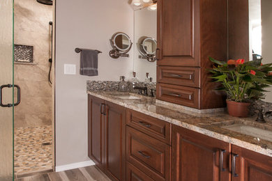 Mid-sized elegant master beige tile and porcelain tile porcelain tile walk-in shower photo in Seattle with raised-panel cabinets, medium tone wood cabinets, a two-piece toilet, beige walls, an undermount sink and granite countertops