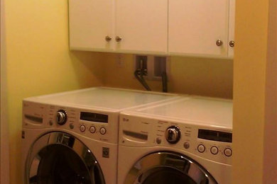 Photo of a small laundry room in Portland Maine with white cabinets and yellow walls.