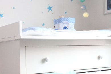 Mittelgroßes Skandinavisches Babyzimmer mit weißer Wandfarbe, braunem Boden und dunklem Holzboden in Hamburg