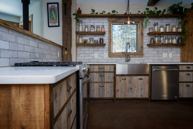Example of a small mountain style l-shaped concrete floor, red floor and exposed beam open concept kitchen design in Burlington with a farmhouse sink, shaker cabinets, dark wood cabinets, quartz countertops, gray backsplash, ceramic backsplash, stainless steel appliances, no island and white countertops