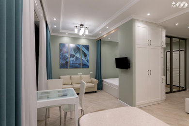 На фото: открытая гостиная комната в современном стиле с зелеными стенами, полом из керамогранита, телевизором на стене и бежевым полом без камина с