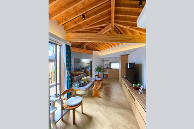 Foto de salón abierto nórdico de tamaño medio sin chimenea con paredes blancas, suelo de madera clara, televisor independiente, suelo beige y vigas vistas