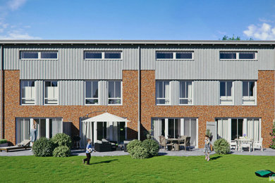 Dreistöckiges Modernes Reihenhaus mit Backsteinfassade, grauer Fassadenfarbe, Pultdach, Ziegeldach, schwarzem Dach und Verschalung in Hamburg