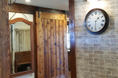 Example of a mid-sized mountain style medium tone wood floor entryway design in Phoenix with white walls and a dark wood front door