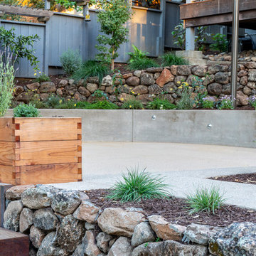Wood timber raised bed, dry stacked rock wall, and DG patio