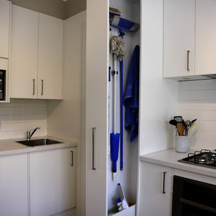 Immagine di una cucina minimal di medie dimensioni con ante lisce, ante bianche, top in quarzo composito, paraspruzzi bianco, paraspruzzi con piastrelle in ceramica, elettrodomestici in acciaio inossidabile, pavimento in gres porcellanato, lavello a vasca singola e pavimento beige