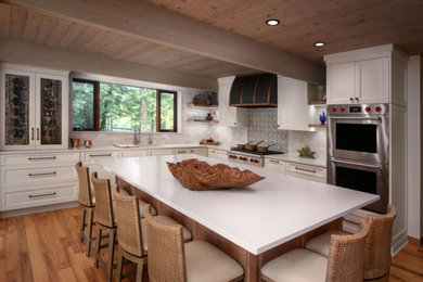 Inspiration for a mid-sized l-shaped eat-in kitchen remodel in Chicago with recessed-panel cabinets, white cabinets, multicolored backsplash, stainless steel appliances, an island and white countertops