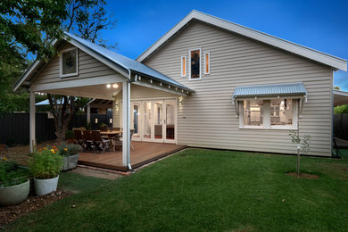 Photo of a mid-sized contemporary one-storey beige house exterior in Perth with wood siding, a gable roof and a metal roof.