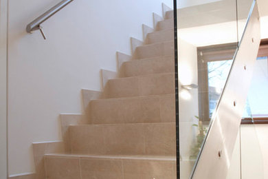 Imagen de escalera en U actual de tamaño medio con escalones de piedra caliza, contrahuellas de piedra caliza y barandilla de metal