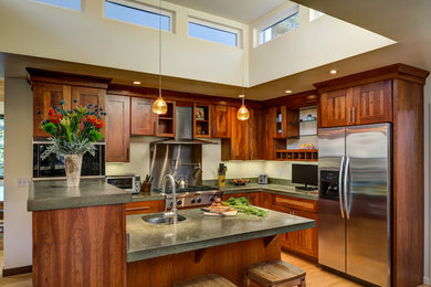 Photo of a mid-sized arts and crafts l-shaped eat-in kitchen in San Francisco with an undermount sink, shaker cabinets, medium wood cabinets, concrete benchtops, stainless steel appliances, light hardwood floors and with island.