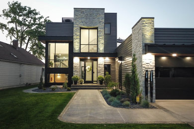 Example of a large trendy black two-story metal exterior home design in Other with a mixed material roof and a black roof