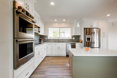 Inspiration for a large transitional l-shaped eat-in kitchen in Los Angeles with a single-bowl sink, shaker cabinets, white cabinets, quartzite benchtops, multi-coloured splashback, porcelain splashback, stainless steel appliances, porcelain floors, with island and multi-coloured floor.
